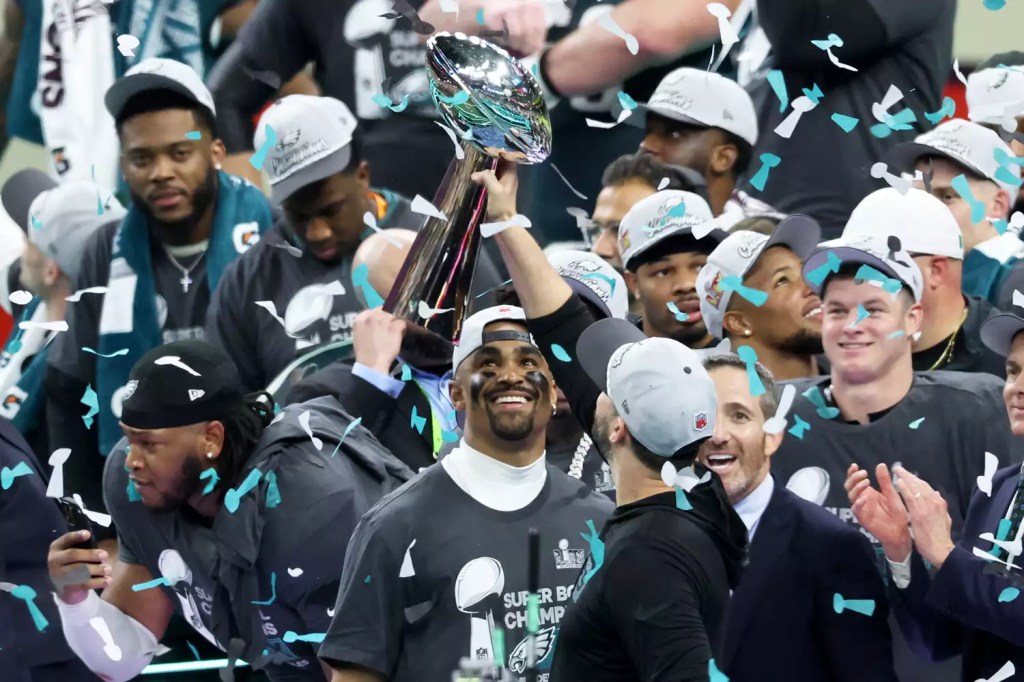 Eagles win the Super Bowl and Jalen Hurts looks on at the Lombardi Trophy